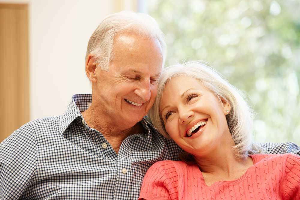 older couple leaning onto each other smiling