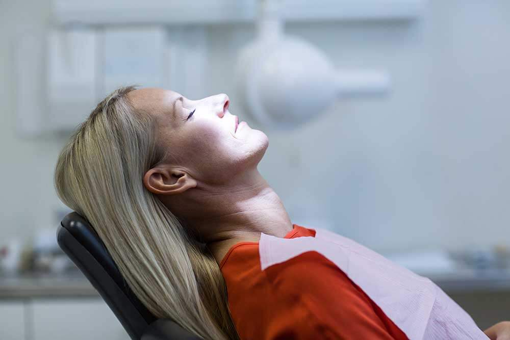 woman in dentist chair preparing for treatment